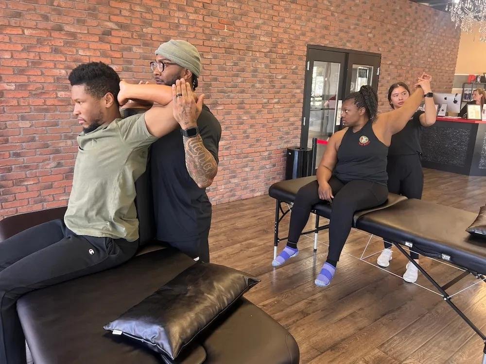 Two men and two women engaged in a stretching session in a wellness studio.